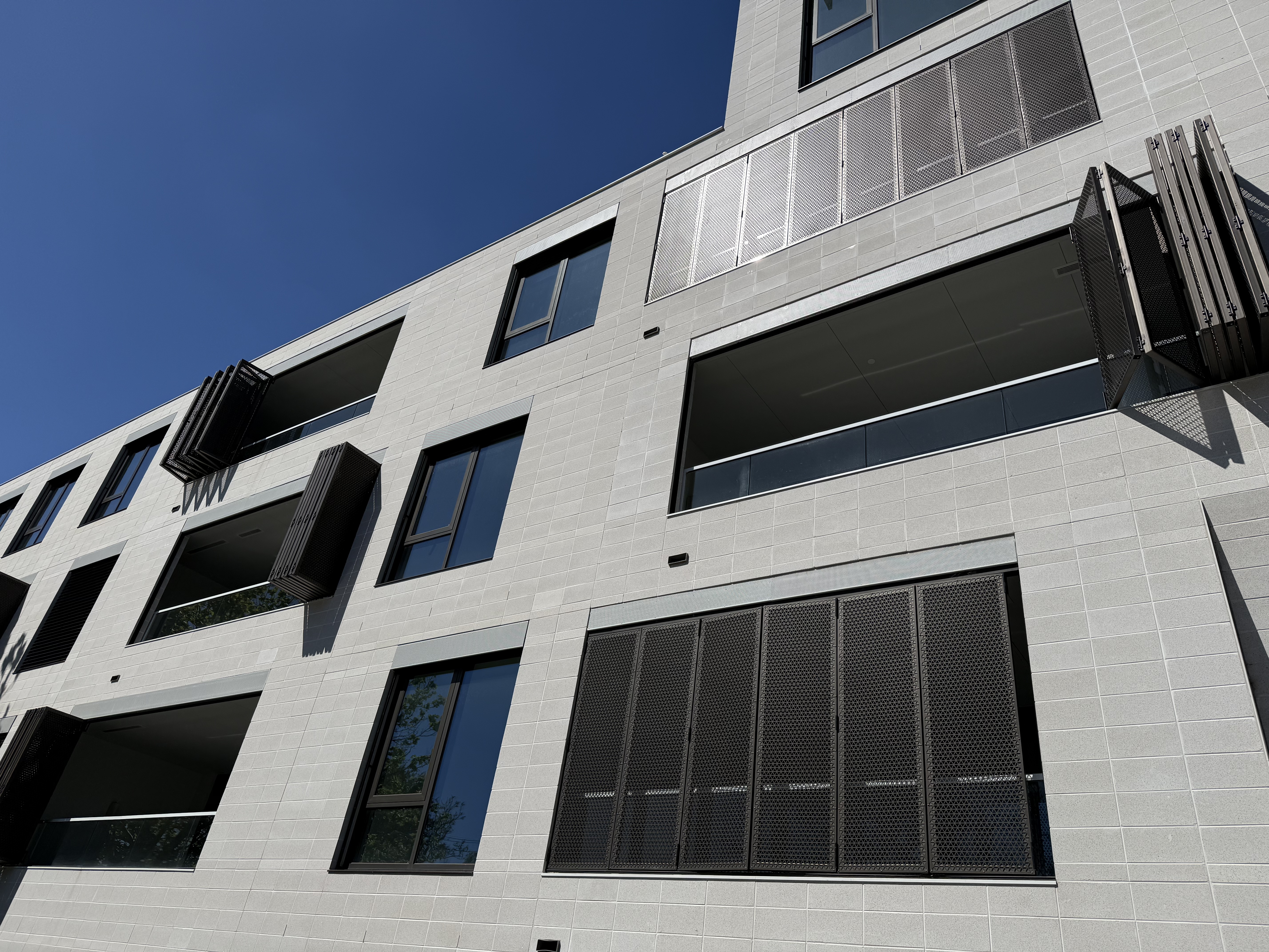 Contemporary apartment exterior with black aluminium windows and architectural screening